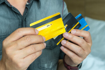 Woman holding several credit cards and he is choosing a credit card to pay and spend Payment for...