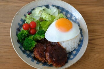 Hamburg steak and rice on the fried egg on the plate
