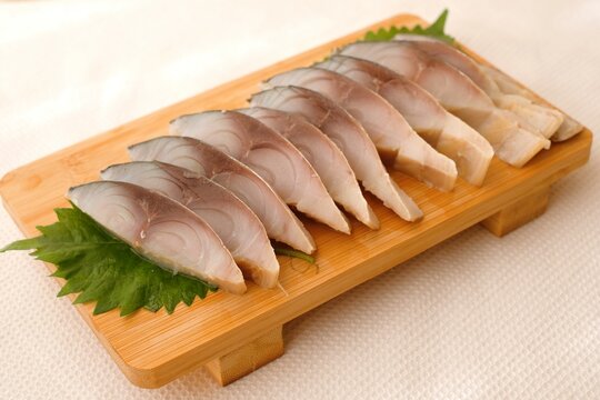 soused mackerel (shimesaba) on wooden board
