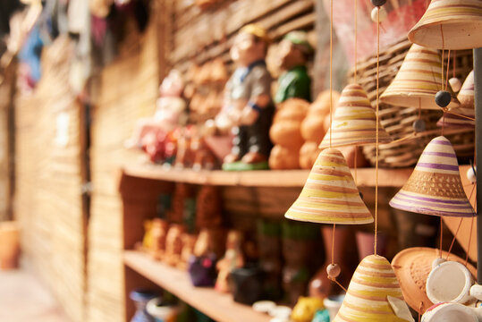Sale of ceramic handicrafts in Raquira, Boyaca, Colombia. A hanging bell ornament stands out in the foreground, in a composition with copy space and selective focus.