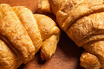 Freshly baked croissant on a wooden background. Top view