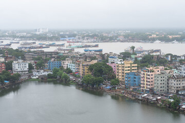 Obraz premium aerial view of the cityscape and waterbody with river karnaphuli in the background, chittagong, bangladesh