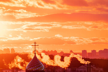 Vibrant colors illuminate the sky at sunset, with smoke wafting from city buildings