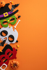 Festive Halloween vertical masks with pumpkins and candy placed on a bright orange surface