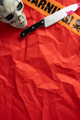 Brightly illuminated vertical Halloween scenery featuring a skull, a knife, and orange warning signs