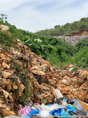 Overflowing domestic garbage at landfill background. Stock photo.