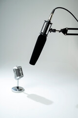 Studio microphone for podcasting or streaming on a boom arm with a vintage classic mic on a white background