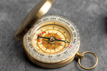 Closeup view of navigational compass on black background. Travel guidance equipment