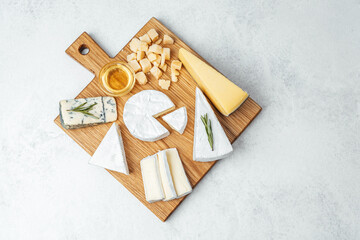 Cheese platter featuring various types of cheeses on a wooden board