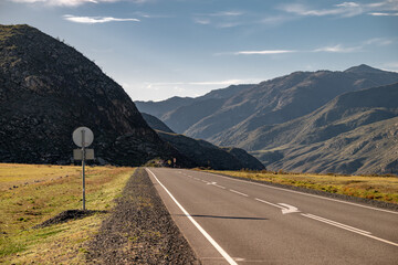 Straight mountain highway road at sunset time. Chuiskiy trakt, Siberia, Russia