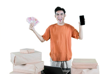 Happy Young Entrepreneur Holding Indonesian Rupiah Cash and Smartphone with Packages – Online...