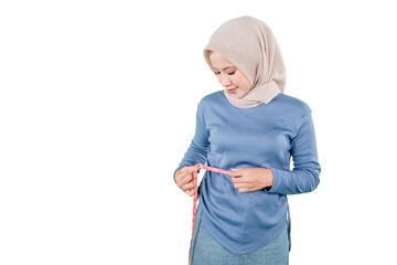 Muslim Woman Checking Waist Size with Measuring Tape