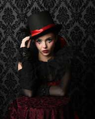 Close-up  glamour portrait of circus burlesque model wearing top hat and gothic gloves, theatrical...