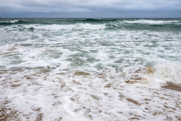 crashing waves on the beach in the evening