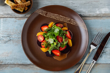 Fresh beetroot salad with orange slices and green leaves