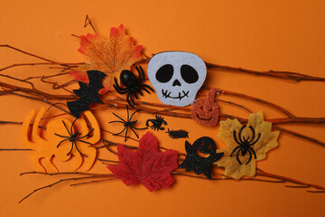 Halloween with skull, ticks, orange maple leaves, bats, spiders on orange background with space for...