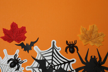 Halloween with skull, ticks, orange maple leaves, bats, spiders on orange background with space for...