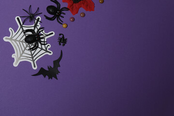 Halloween with skull, ticks, orange maple leaves, bats, spiders on purple background with space for...
