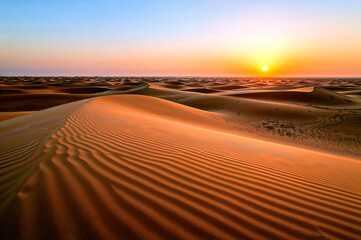 Naklejka premium Serene sunset over flowing beige sand dunes