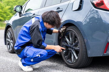 タイヤの整備をする男性整備士 Male mechanic servicing a tire