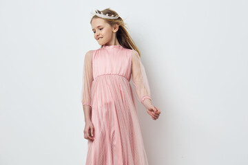 Lovely young girl in a pink dress, exuding joy and confidence, with soft blonde hair and a dreamy...