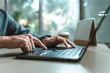 Businessman is hand working and typing on laptop. Business, corporate and finance concept.