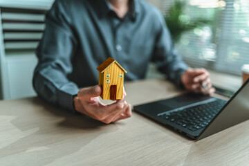 Home salesman, insurance salesman Holding a house in hand. Assets, real estate, loans and property...