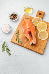 Preparing fresh salmon fillet on a wooden cutting board with herbs and spices