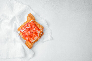 Delicious strawberry pastry sits on a white cloth in a bright kitchen