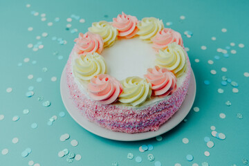 Colorful layered cake with frosting on blue background ready for celebration