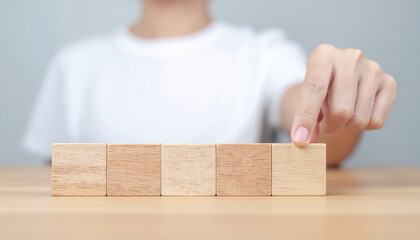 Concept of hand align. A horizontal line of  blank small wooden blocks. Strategic business component concept.
