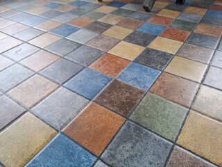 A pattern of square tiles in various colors and textures.	
