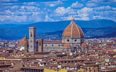 The dome of Santa Maria del Fiore dominates the Florence skyline, while the Church of San Lorenzo stands in the background, adding depth to the city's historic panorama.