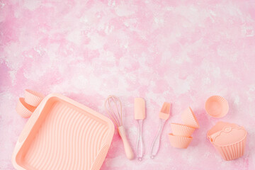Pink baking tools and whisk on soft pink wall background