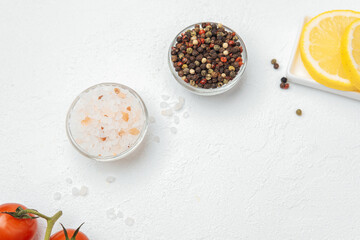 Himalayan salt and pepper mix with lemon slices on white background