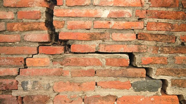 Cracked antique red brick wall with aged lines and crumbling surface from temple ruins