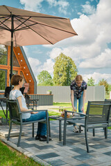 A young woman brought plates to the patio table to lay out grilled food