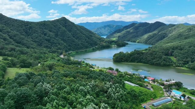Cinematic drone footage of forested mountains and lake valley in Chuncheon, South Korea