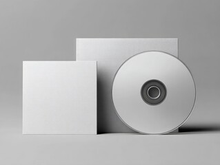 A blank CD and two square cardstock inserts rest on a neutral gray background, showcasing a clean, minimalist design ideal for packaging mockups