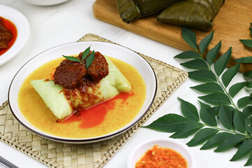Buras, Indonesian traditional rice cakes from Makassar, South Sulawesi. Buras made from rice, coconut milk and salt wrapped with banana leaves and served with savory soup and beef or chicken.