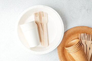 White and brown disposable tableware with paper cups and wooden forks
