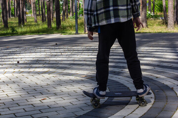 child riding a steak in the park, skateboarding, summer vacation in the park, boy riding a skateboard close-up