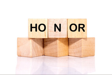 The HONOR concept word is assembled from wooden cubes. ethics, respect, code, honesty, integrity...