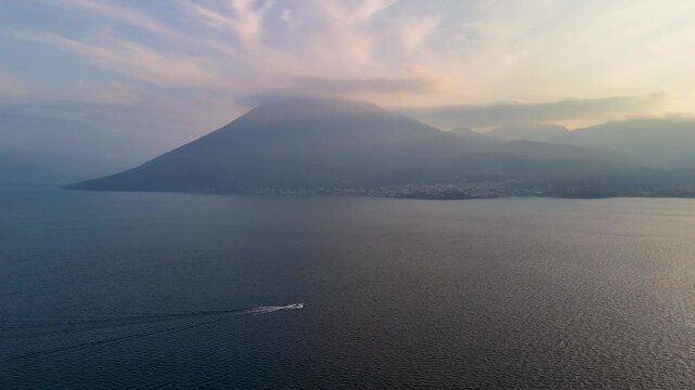 Aerial drone shot of Lake Atitlan and a boat at sunset, Guatemala.	