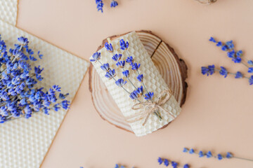 Beeswax candle with lavender tied on wood slice flatlay