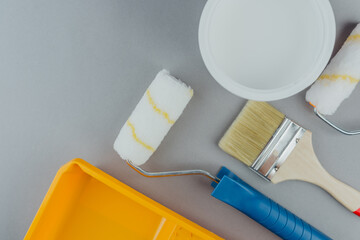 Top view of painting tools including brushes and rollers with white paint for home renovation and...