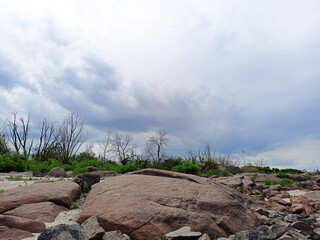 A celestial panorama from the rocky coast of the Dnieper River of heavy rain clouds through which...
