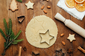 Christmas cookie dough cutting with star shapes and tree cookies for holiday food and festive...