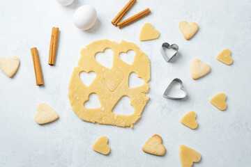 Heart cookies and baking dough on pastel background with cinnamon for romantic, food blog or recipe concept