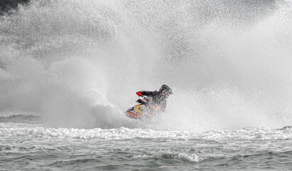 A jet ski cuts through the water, creating a dramatic splash capturing the excitement of...